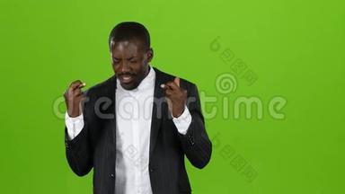 非裔美国人<strong>跨越</strong>他的手指，希望在他的努力中有一个快乐的时刻。 绿色屏幕